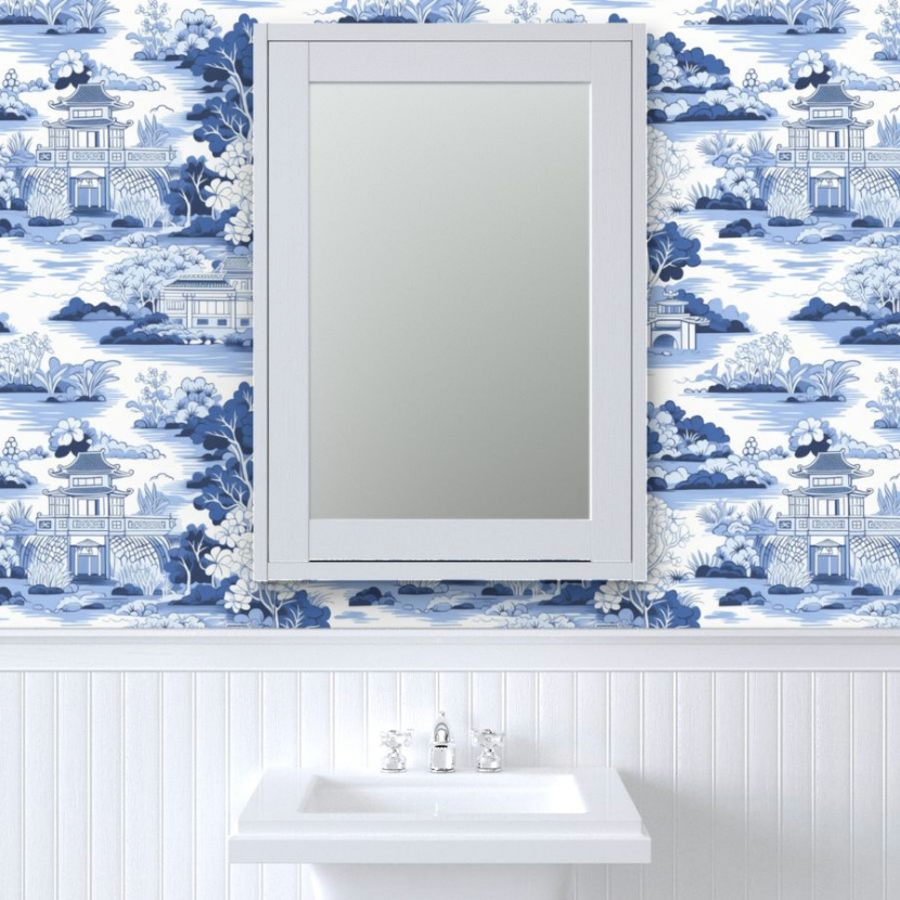 Replace with: A bathroom mirror above a sink against a wall with decorative Large Blue Chinoiserie Wallpaper from Stannie & Lloyd and art on walls.