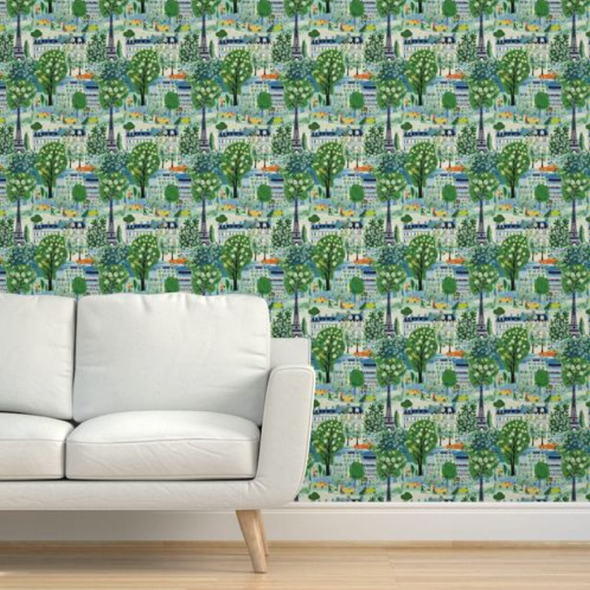 A modern white sofa against a wall adorned with Spring in Paris Wallpaper by Stannie & Lloyd in a vibrant green botanical pattern.
