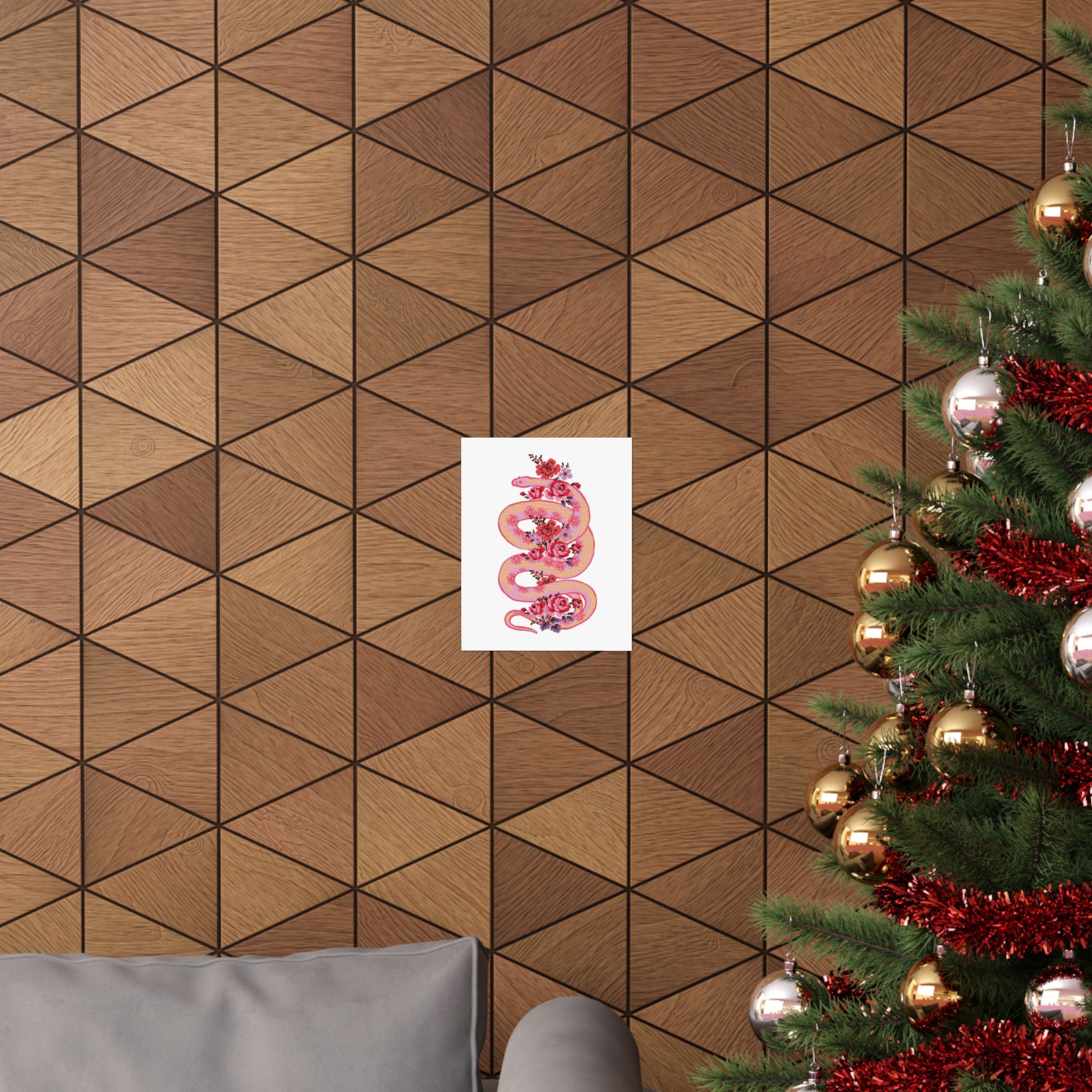 A geometric wood-paneled wall features the Printify "Snake with Roses" large matte poster; part of a decorated Christmas tree and a gray sofa appear in the foreground.