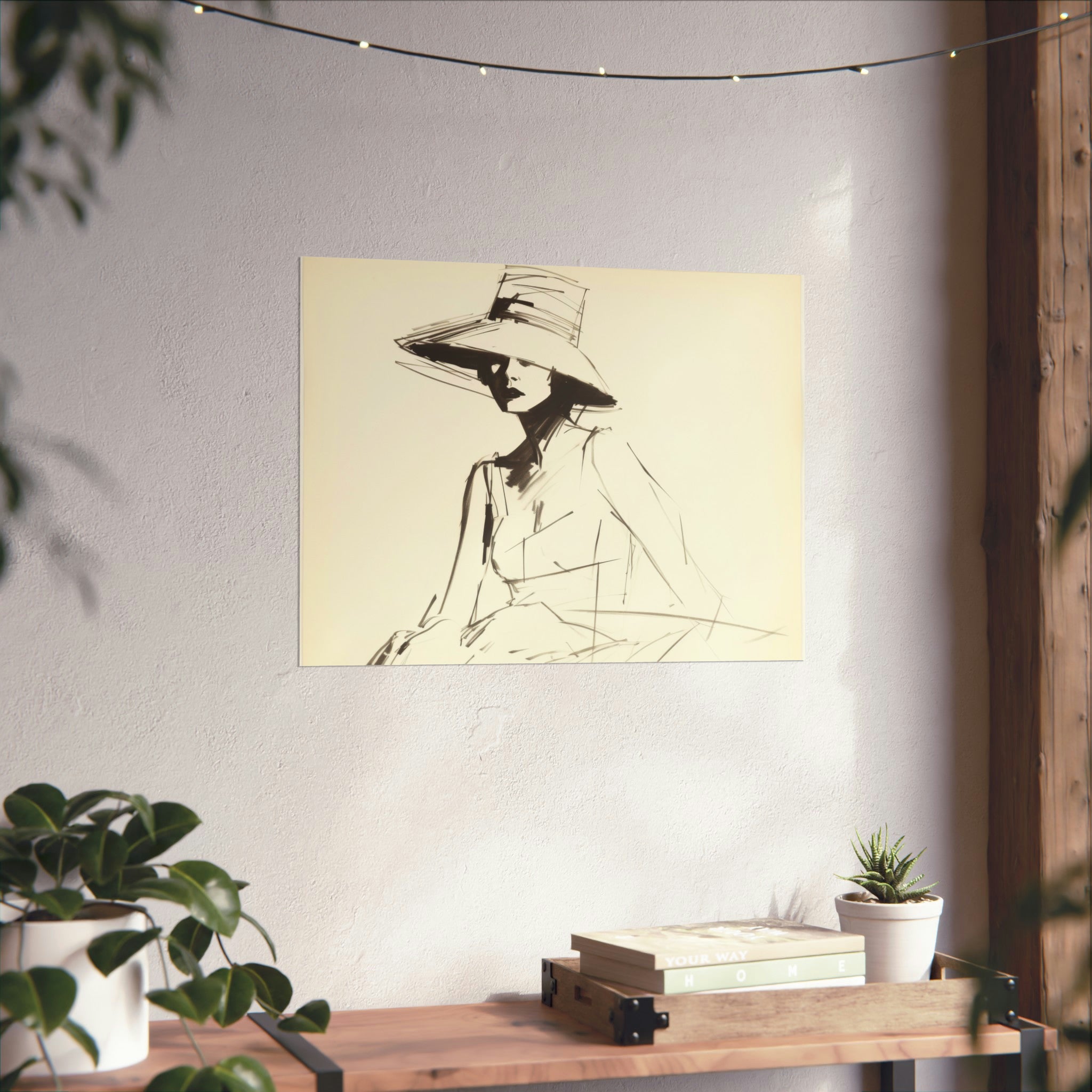 A monochromatic vintage Fashion Sketch by Printify of a figure in a wide-brimmed hat, displayed in a simple frame on a wall above a wooden shelf with books and plants.