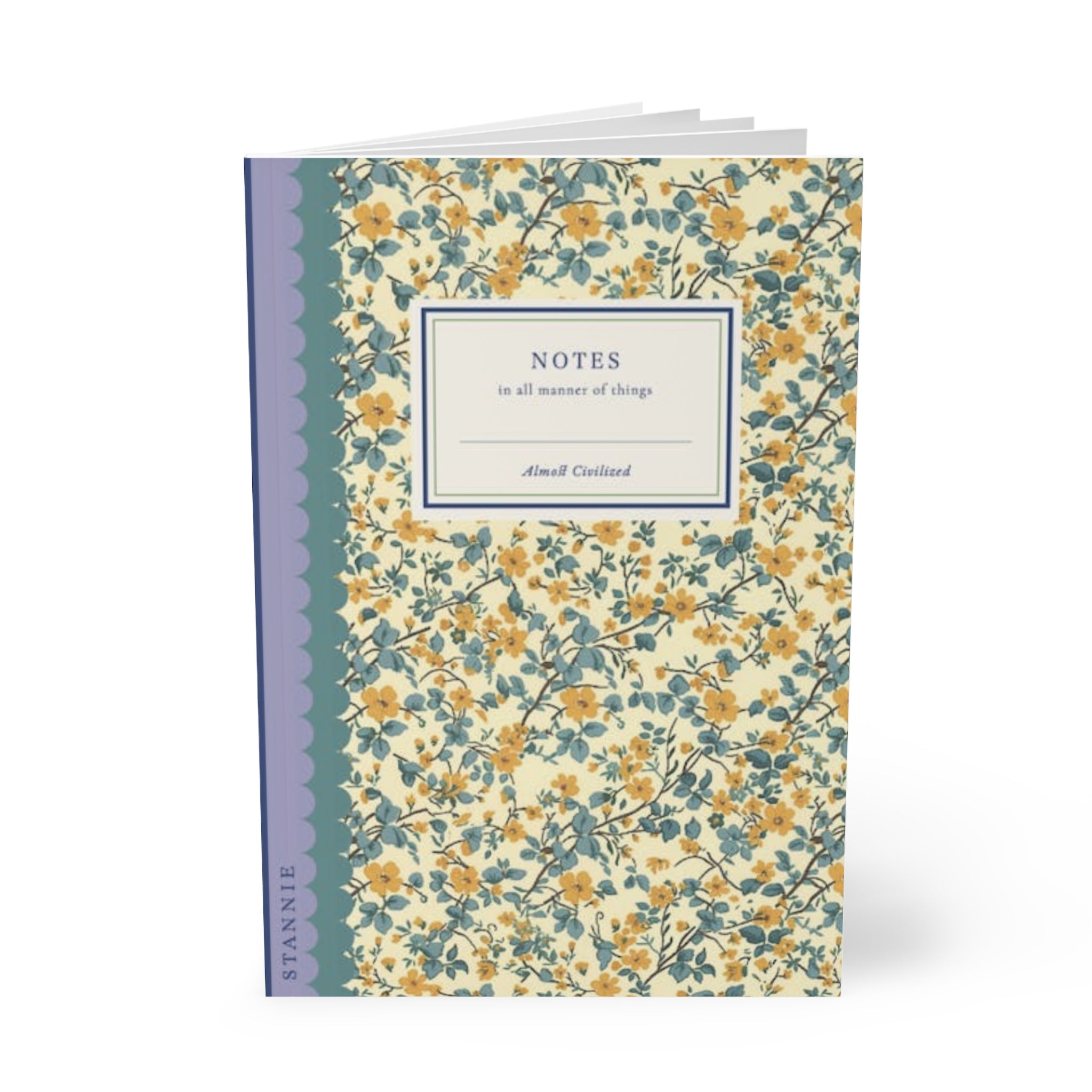 Image of a calico Softcover Notebook, A5 with a floral cover design, a blue spine, and a label reading "NOTES in all manner of things" by "Printify." The cover is decorated with yellow and blue flowers. This customizable notebook features lined paper, perfect for capturing all your thoughts.