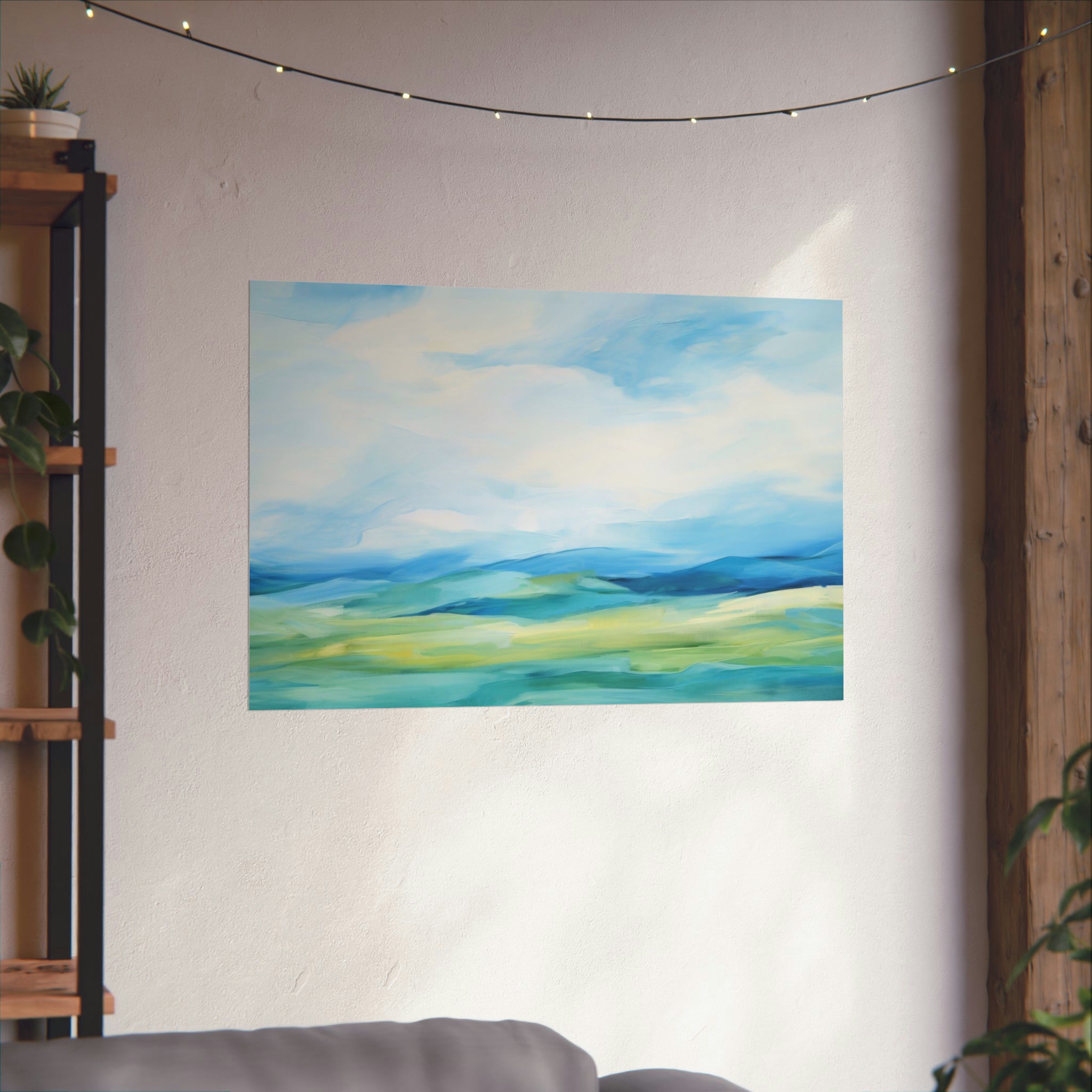 A serene Distant Blues poster from Printify hung on the wall above a couch, with ambient string lights and greenery in the room.