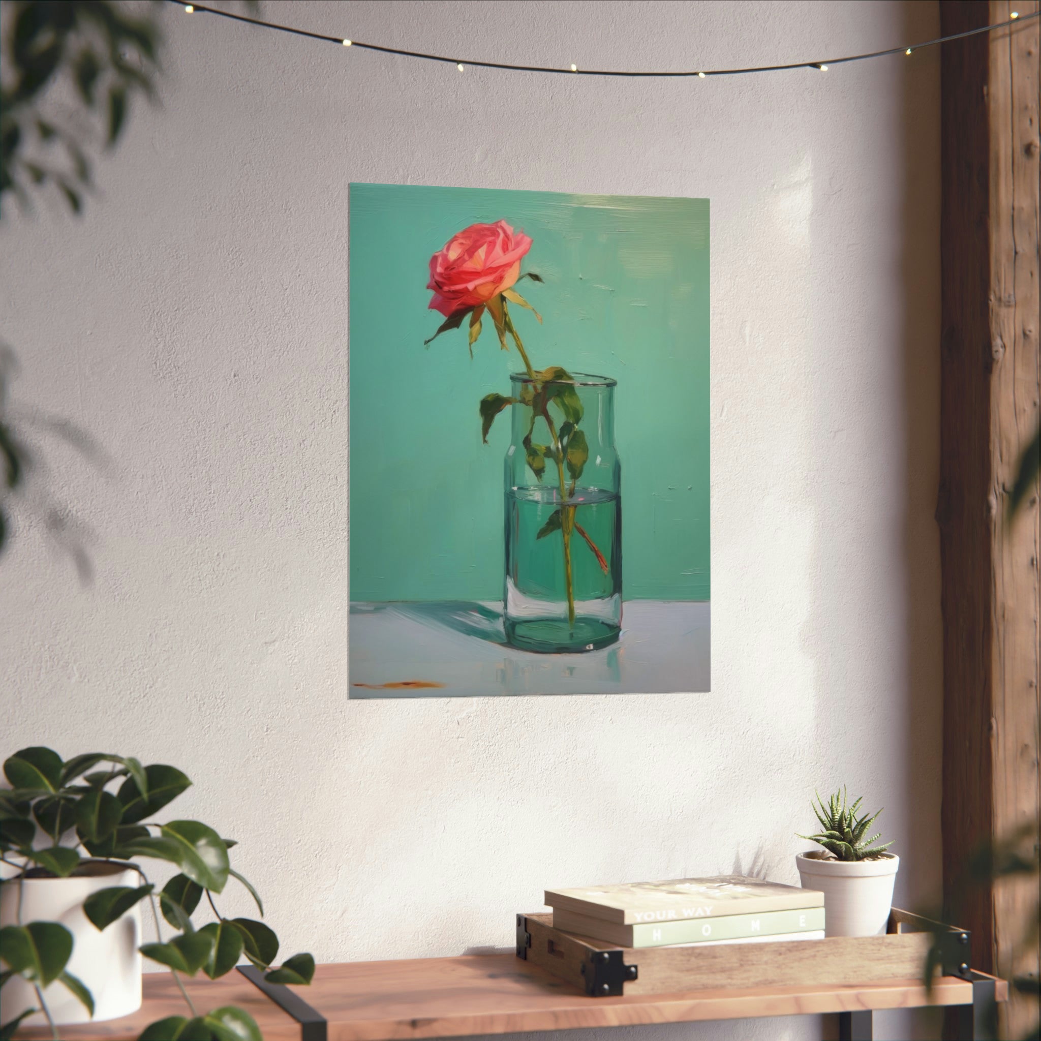 A vintage art piece of a rose in a **Glass of Water in Greens** vase hanging on walls with art above a wooden shelf with books and potted plants from **Printify**.