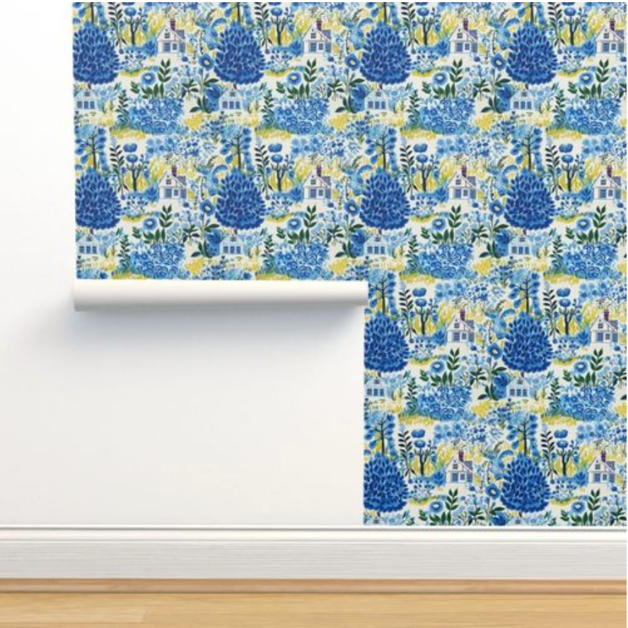 A roll of Cozy Cottage in Blue Wallpaper by Stannie & Lloyd with a floral and architectural pattern vintage art against a white wall.