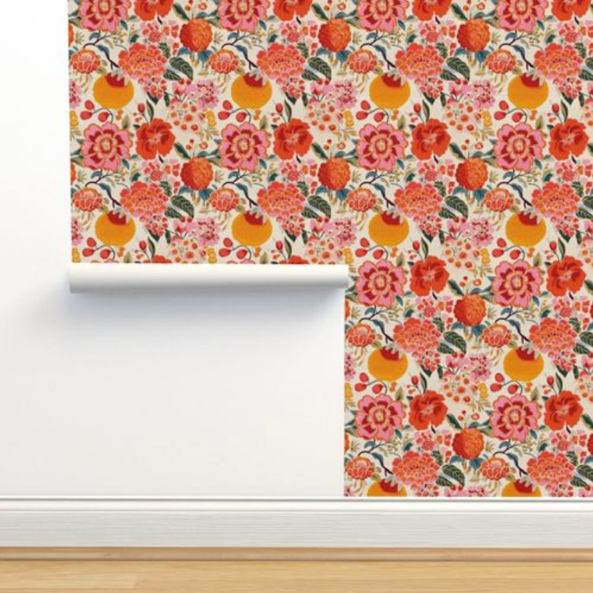 Wall art for living room with a Pink Berries & Flowers Wallpaper from Stannie & Lloyd being unrolled against a wall.